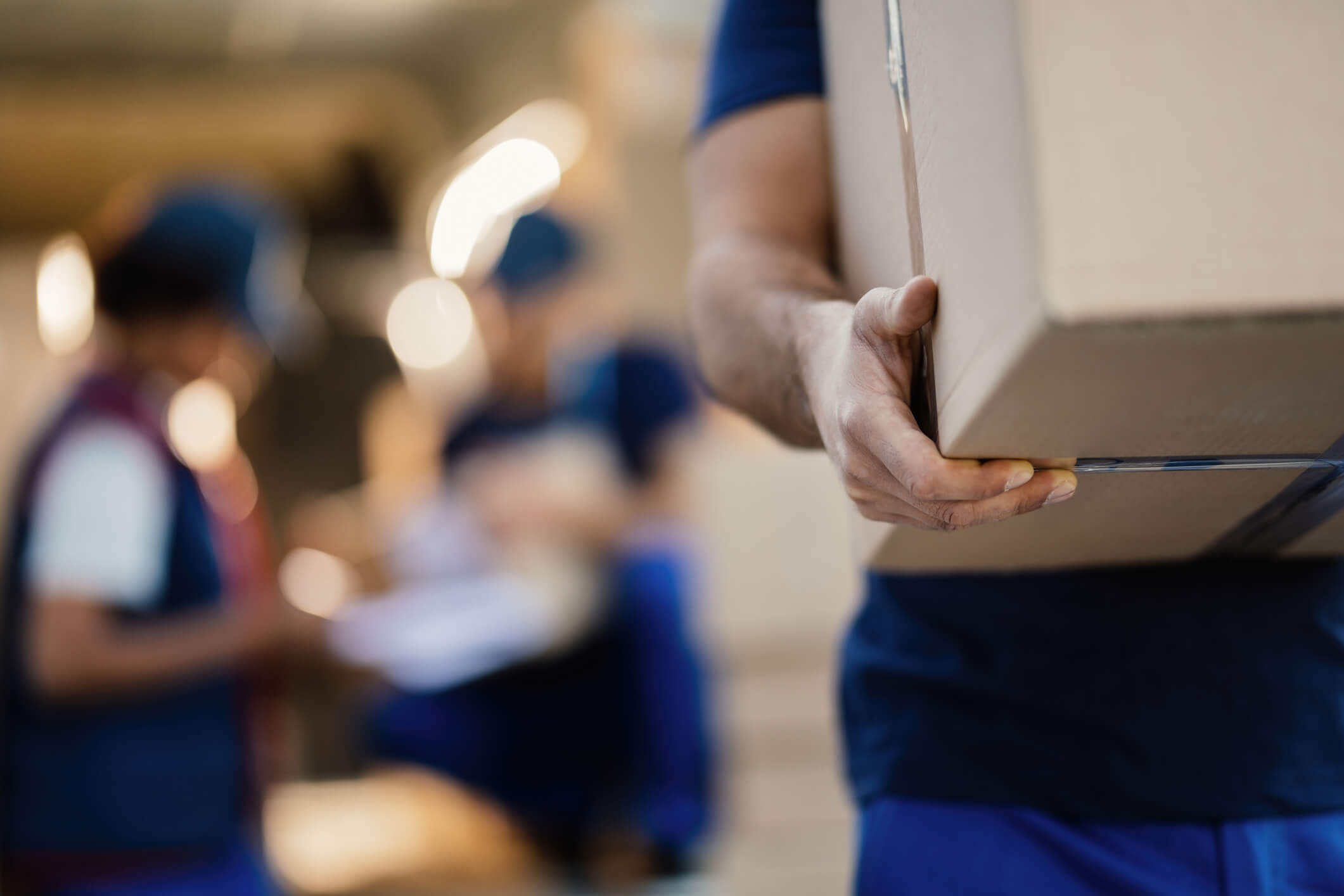 Close-up of unrecognizable delivery man with cardboard box.