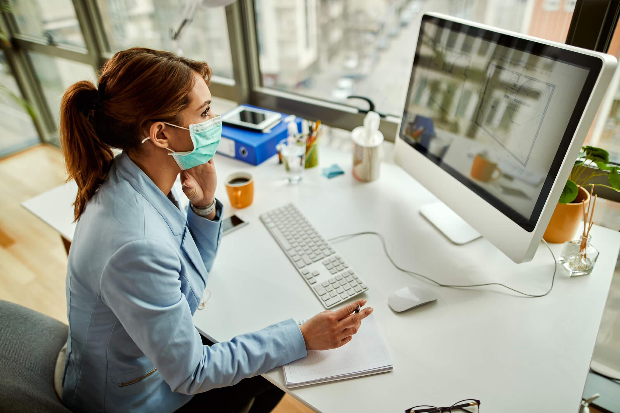 How COVID-19 has Changed HR: Female working on computer with mask