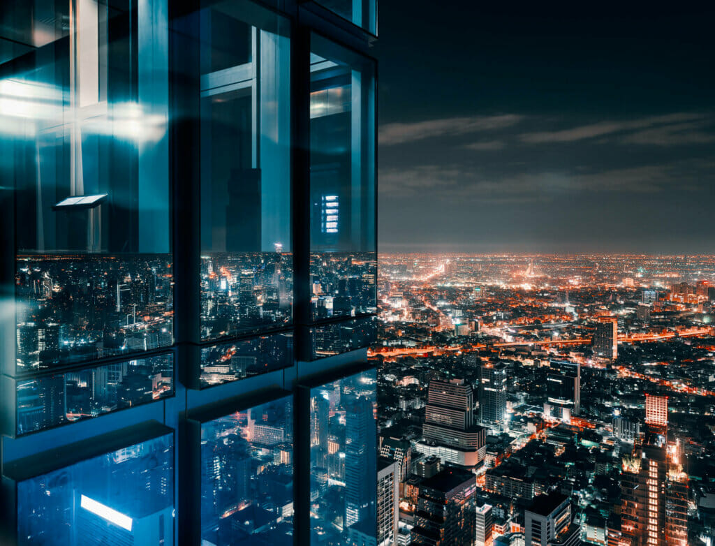 Glass window with glowing crowded city,concept: power the resilience imperative